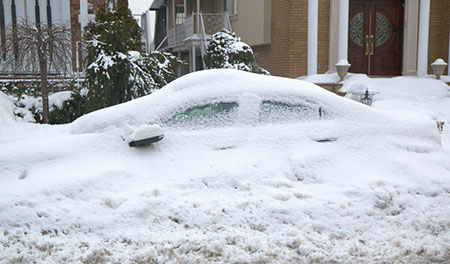 Car covered by snow drift