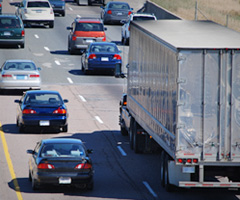 Cars passing a semi truck on the highway