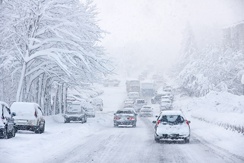 Cars driving on a very snowy road
