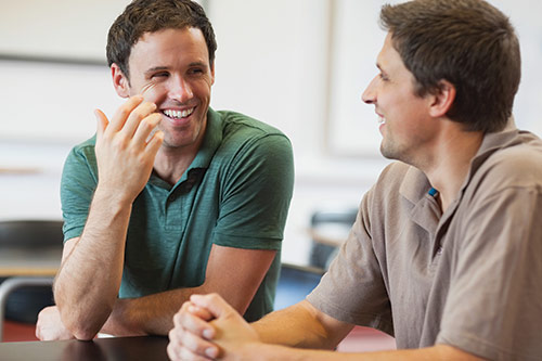 Two young men talking and laughing